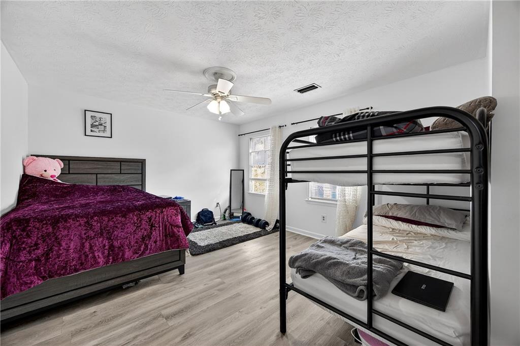 4673 Arrowhead Trail Southwest Lilburn, GA 30047 - Photo 19 of 28 a bedroom with a bed and a chandelier