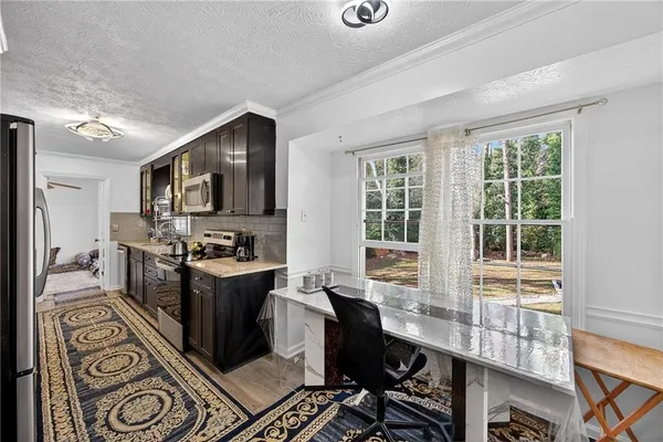 a large kitchen with a large window and stainless steel appliances