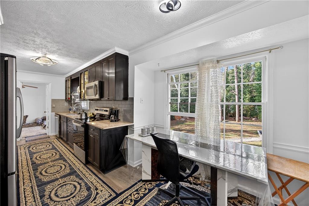 4673 Arrowhead Trail Southwest Lilburn, GA 30047 - Photo 5 of 28 a large kitchen with a large window and stainless steel appliances