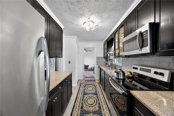 a kitchen with stainless steel appliances granite countertop hardwood floor sink stove and refrigerator