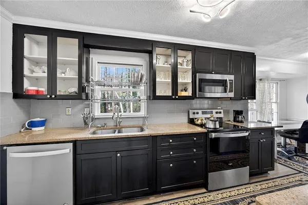 a kitchen with stainless steel appliances granite countertop a sink stove and microwave
