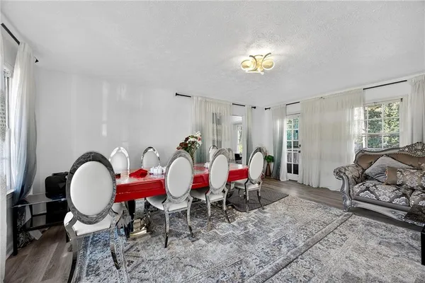 a view of a dining room with furniture a chandelier and wooden floor