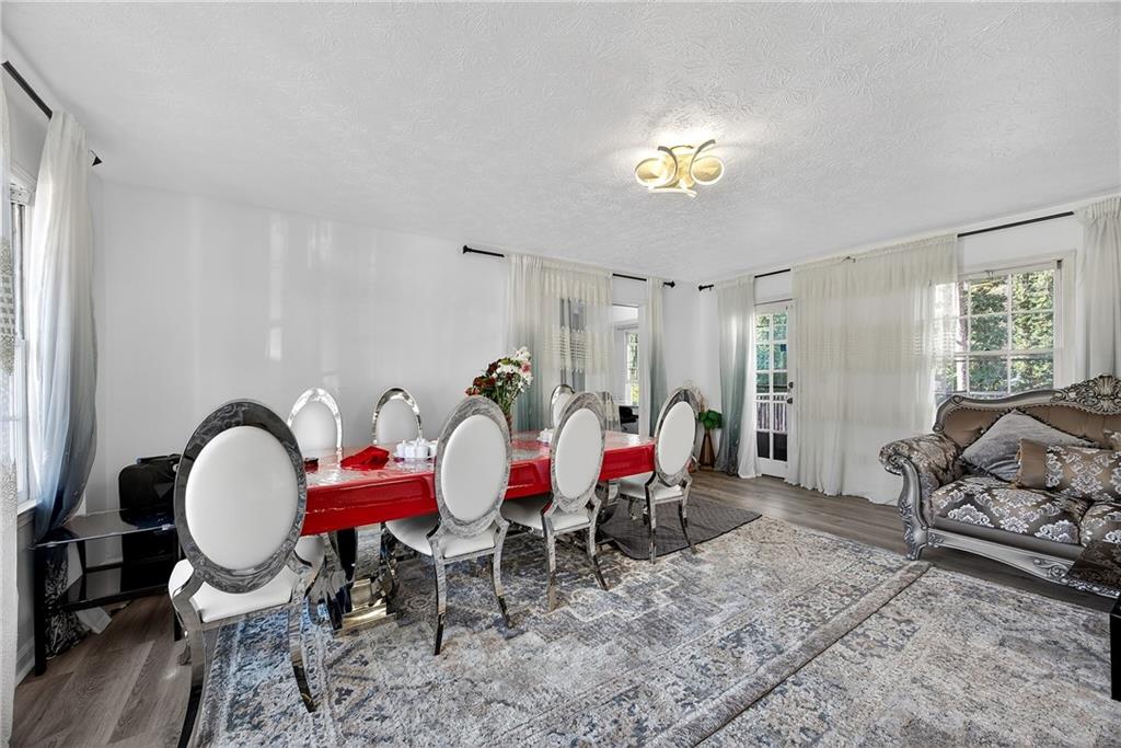 4673 Arrowhead Trail Southwest Lilburn, GA 30047 - Photo 9 of 28 a view of a dining room with furniture a chandelier and wooden floor