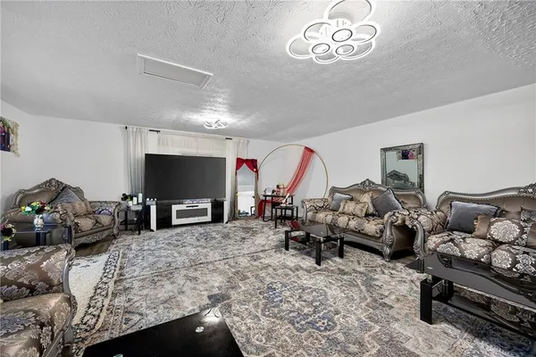 a living room with furniture chess board and a flat screen tv