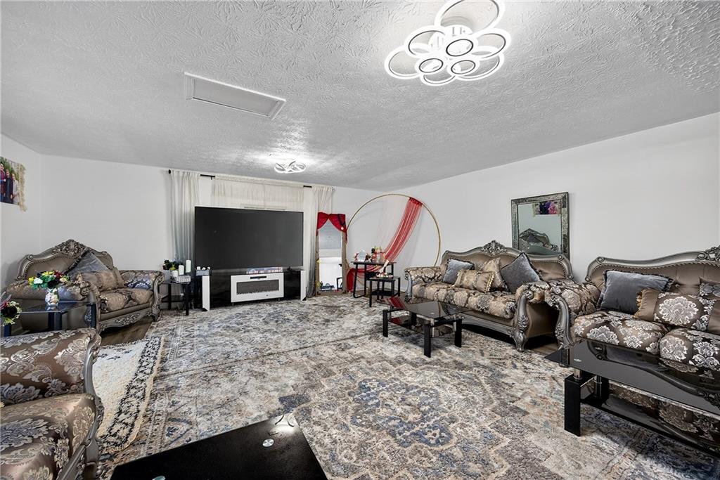 4673 Arrowhead Trail Southwest Lilburn, GA 30047 - Photo 10 of 28 a living room with furniture chess board and a flat screen tv
