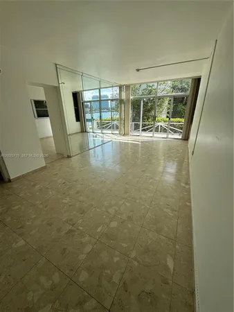 a view of empty room with wooden floor and fireplace