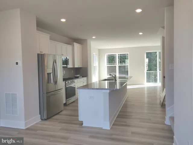 a kitchen with stainless steel appliances granite countertop a refrigerator and a stove top oven