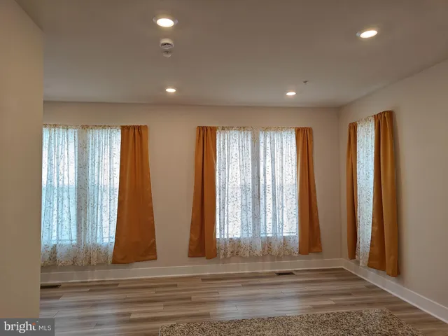 an empty room with windows and curtain