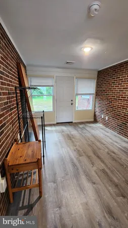 a view of an empty room with wooden floor and windows