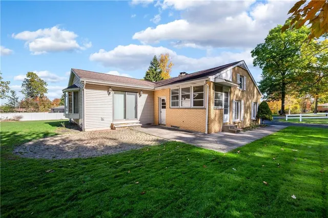 a view of house with backyard and a garden