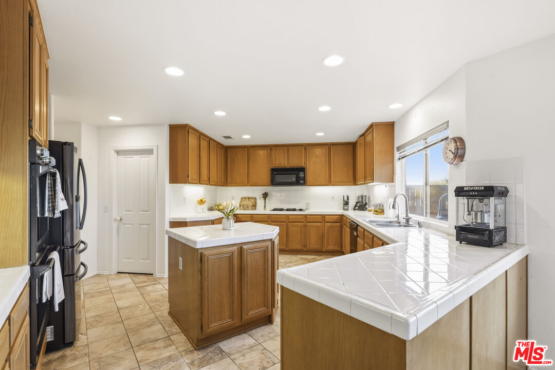 32610 Ridge Top Lane Castaic, CA 91384 - Photo 17 of 49 a kitchen with stainless steel appliances granite countertop a sink a refrigerator and a stove