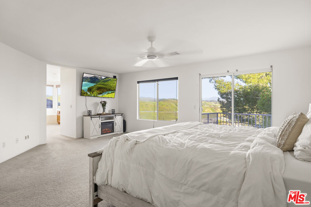 32610 Ridge Top Lane Castaic, CA 91384 - Photo 37 of 49 a bedroom with furniture a flat screen tv and a large window