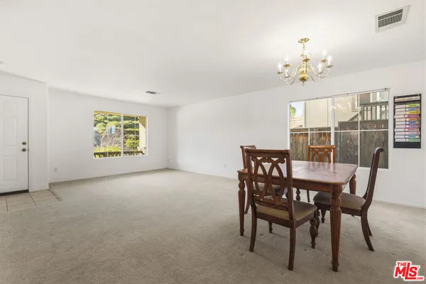 a view of a dining room with furniture wooden floor and a chandelier