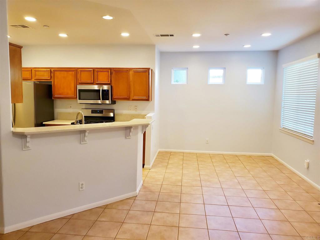 6116 Citracado Circle Carlsbad, CA 92009 - Photo 12 of 32 a kitchen with stainless steel appliances a sink a stove a microwave a refrigerator and cabinets