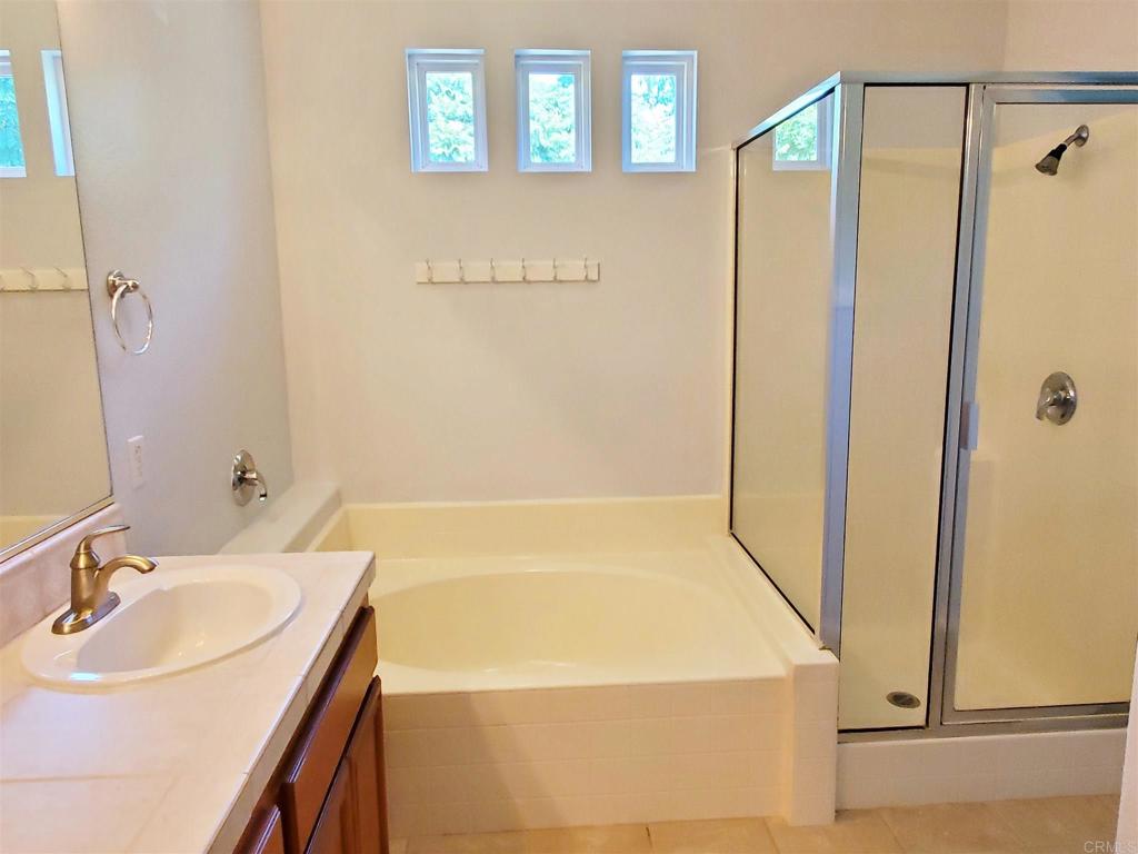 6116 Citracado Circle Carlsbad, CA 92009 - Photo 20 of 32 a bathroom with a sink a shower and a mirror