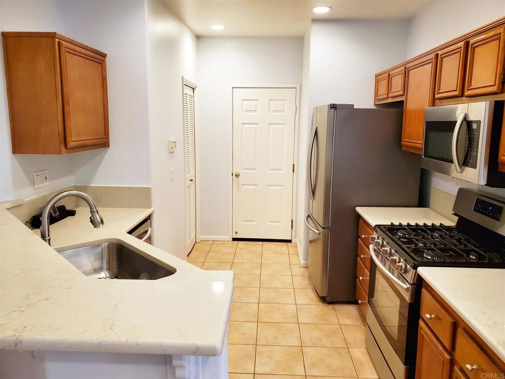 6116 Citracado Circle Carlsbad, CA 92009 - Photo 8 of 32 a kitchen with stainless steel appliances granite countertop a sink a stove and a refrigerator
