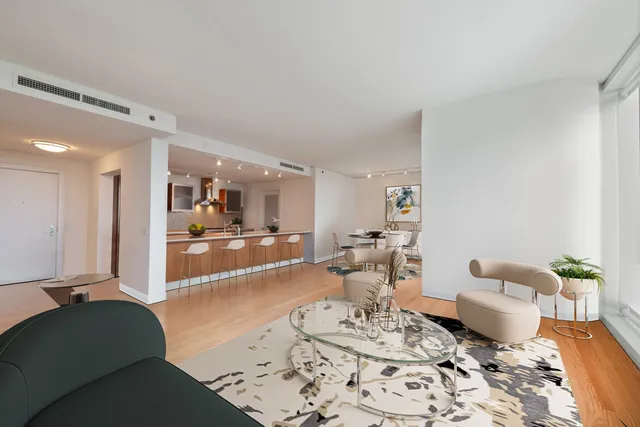 a living room with furniture a rug and kitchen view
