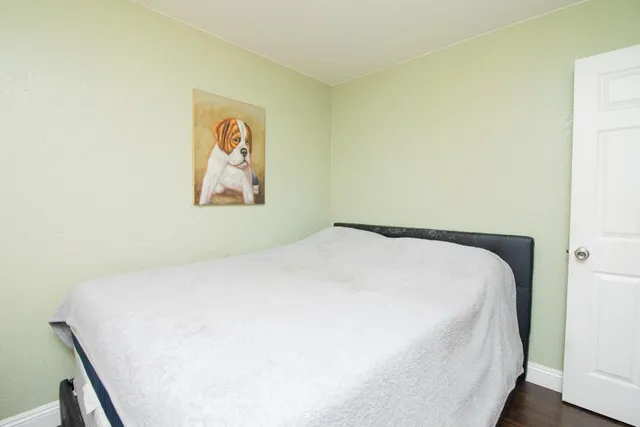 a bedroom with a bed and painting on the wall