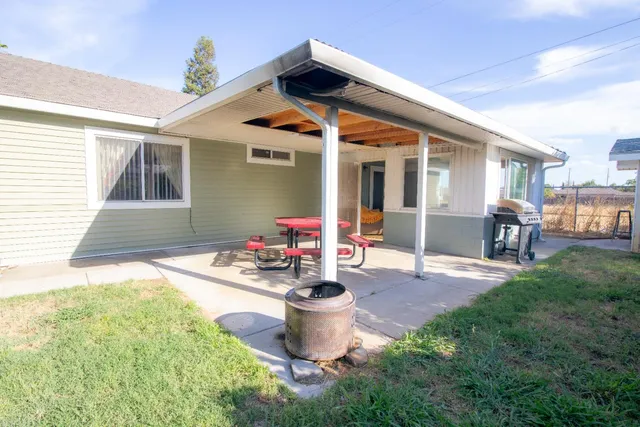 a backyard of a house with table and chairs