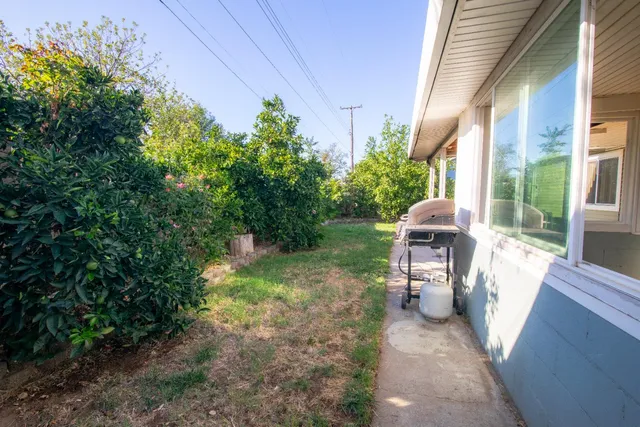 a view of a patio with table and chairs potted plants and large tree