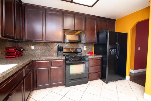 a kitchen with stainless steel appliances granite countertop wooden cabinets a stove top oven a sink and dishwasher