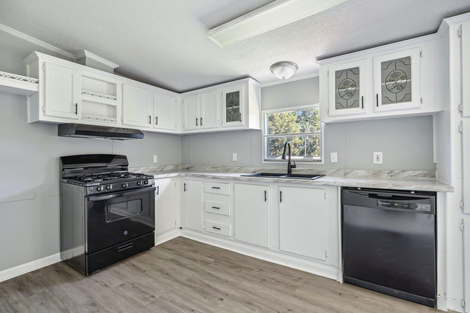 506 Charleston Gift Road Covington, TN 38019 - Photo 8 of 23 Kitchen with black appliances, white cabinetry, and sink