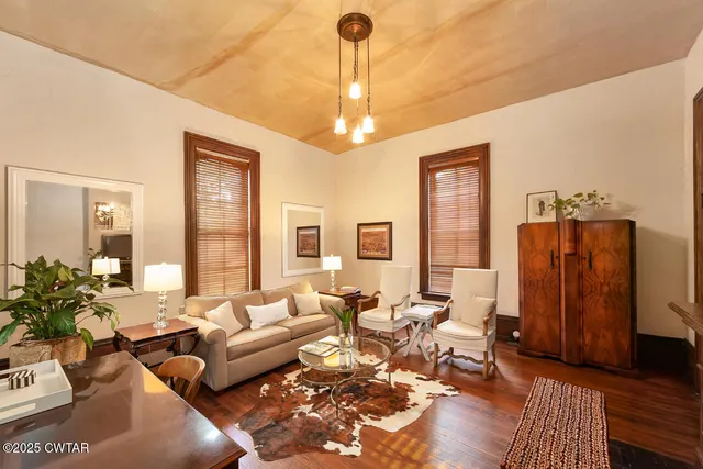 a living room with furniture a large window and a chandelier