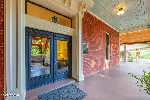 a view of a hallway with wooden floor and a glass door