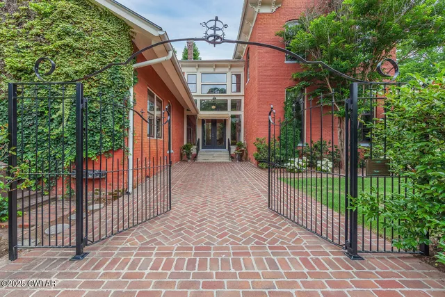 a view of a house with a small yard and wooden fence and plants