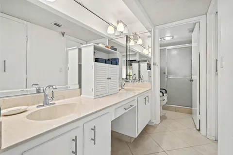 a bathroom with a double vanity sink mirror and shower