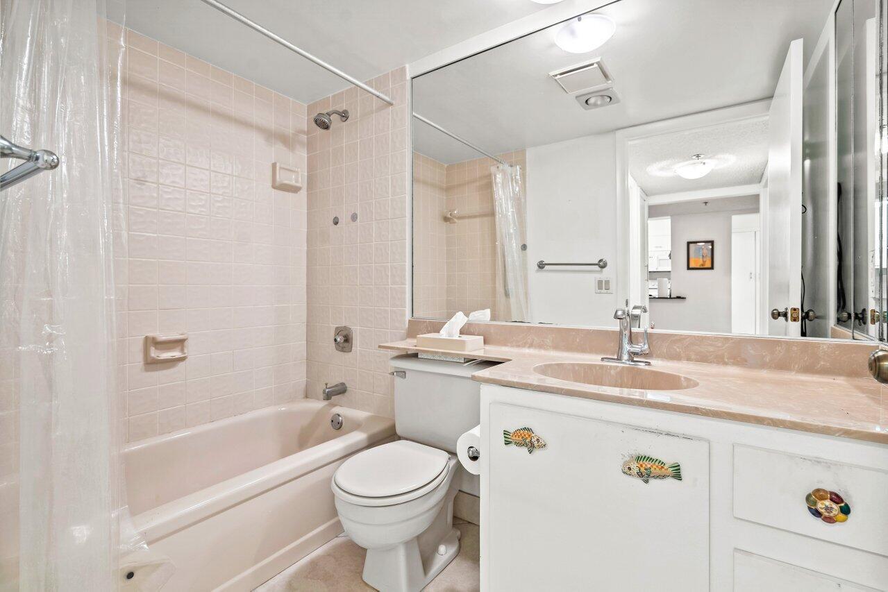 6320 Boca Del Mar Drive, Unit 302 Boca Raton, FL 33433 - Photo 22 of 35 a bathroom with a granite countertop sink a toilet a mirror a bathtub and shower