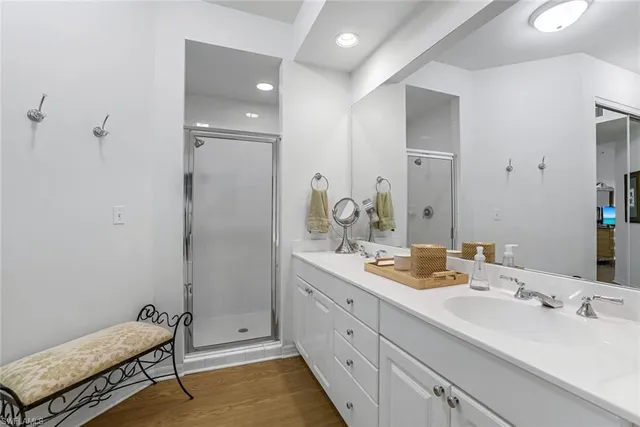 a en suite bathroom with a double vanity sink a mirror and a shower