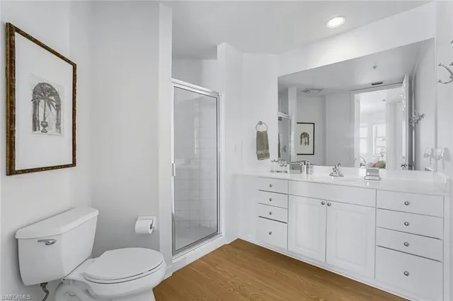 a bathroom with a granite countertop toilet sink and mirror
