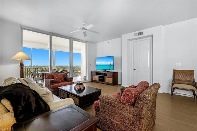 a living room with furniture fireplace and a large window