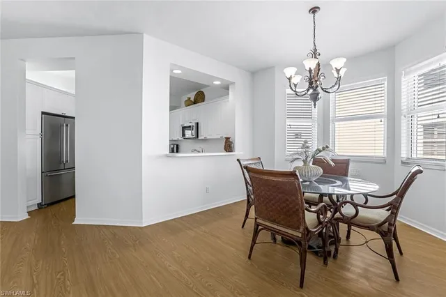 a dining room with furniture a chandelier and wooden floor