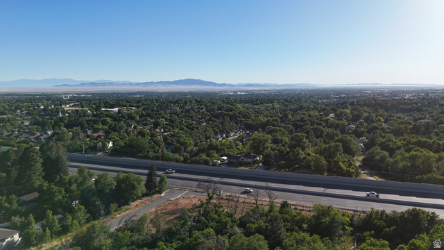 1792 Valley View Drive Layton, UT 84040 - Photo 14 of 18 Expansive aerial perspective showcasing a wide two-lane roadway bordered by lush green foliage