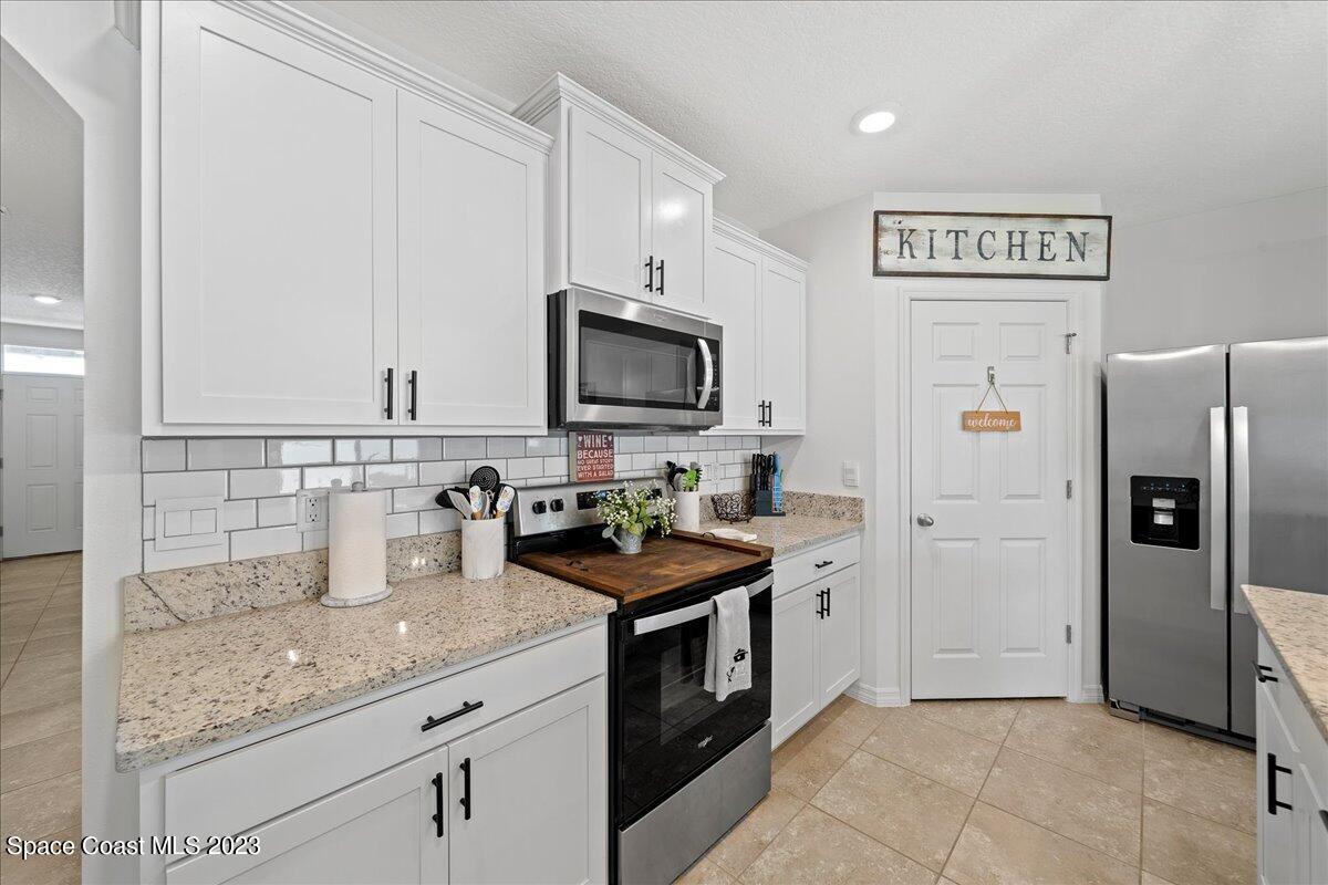 2103 Capital Drive Palm Bay, FL 32909 - Photo 13 of 84 a kitchen with stainless steel appliances granite countertop a refrigerator and a stove