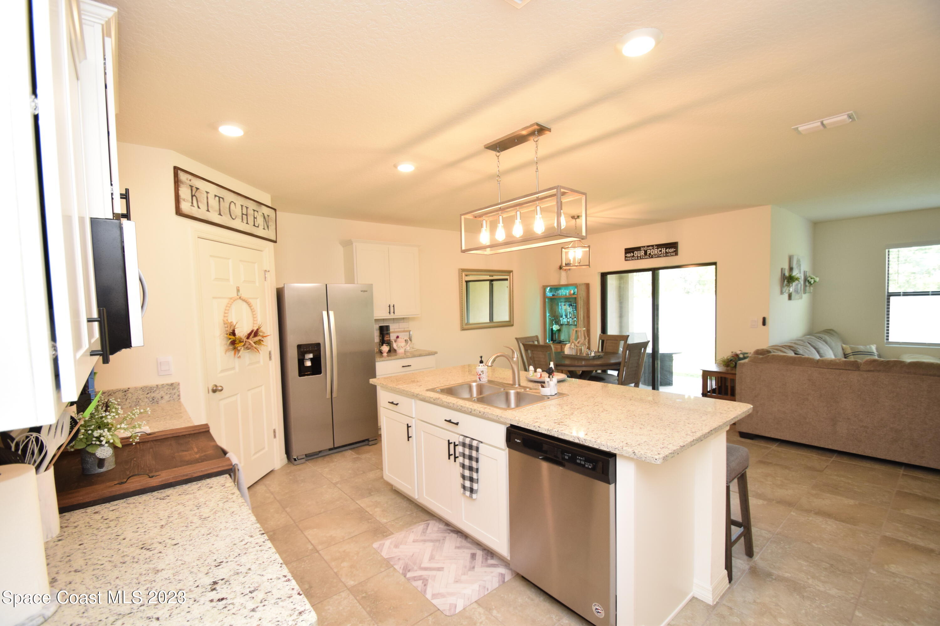 2103 Capital Drive Palm Bay, FL 32909 - Photo 40 of 84 a large white kitchen with stainless steel appliances granite countertop a lot of counter space and wooden floor