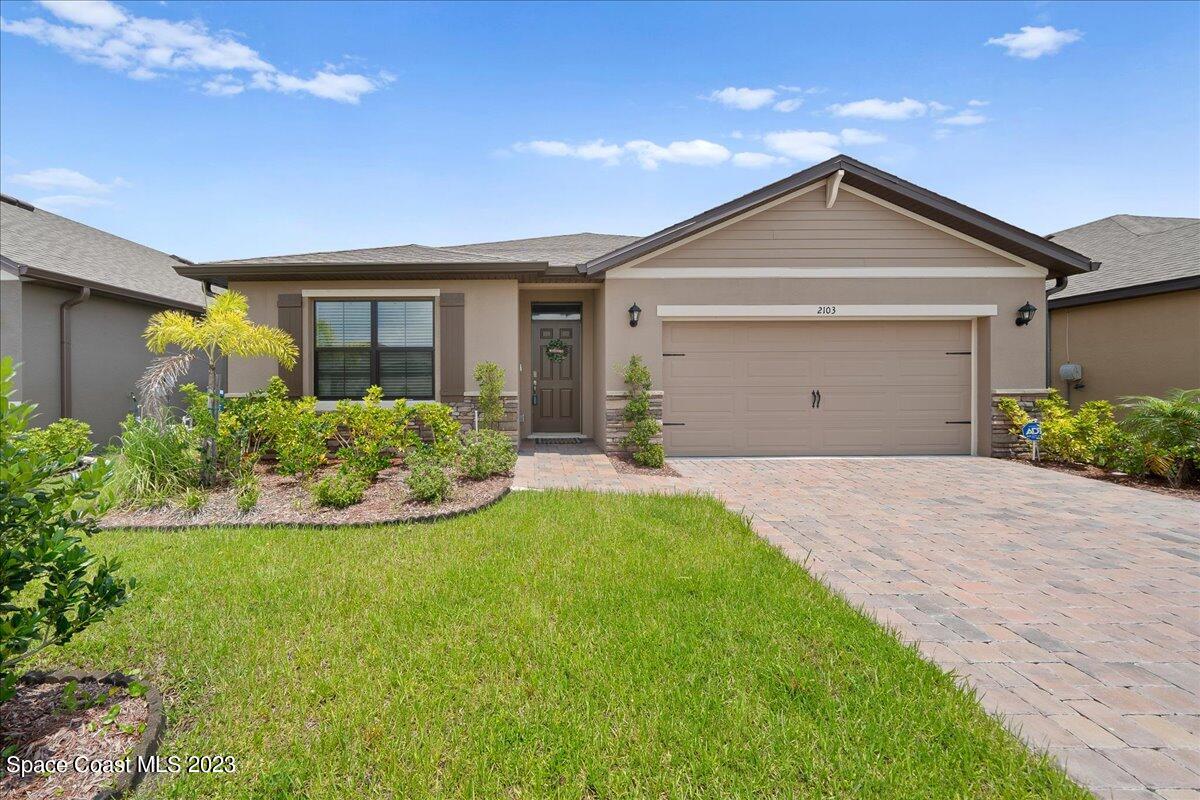 2103 Capital Drive Palm Bay, FL 32909 - Photo 81 of 84 a front view of a house with a yard and garage