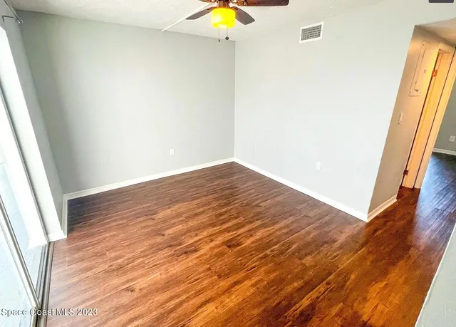 a view of empty room with wooden floor