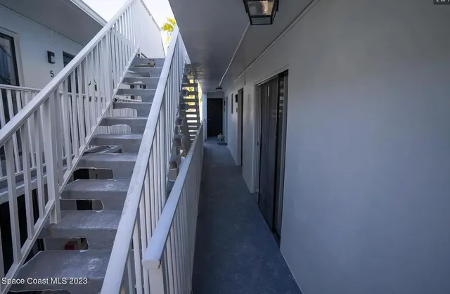 a view of staircase with lots of frames on wall and stairs