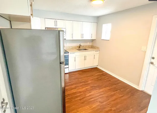 a kitchen with a refrigerator sink and cabinets