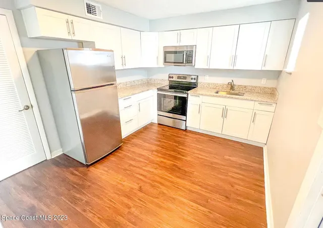 a kitchen with stainless steel appliances a refrigerator sink and microwave