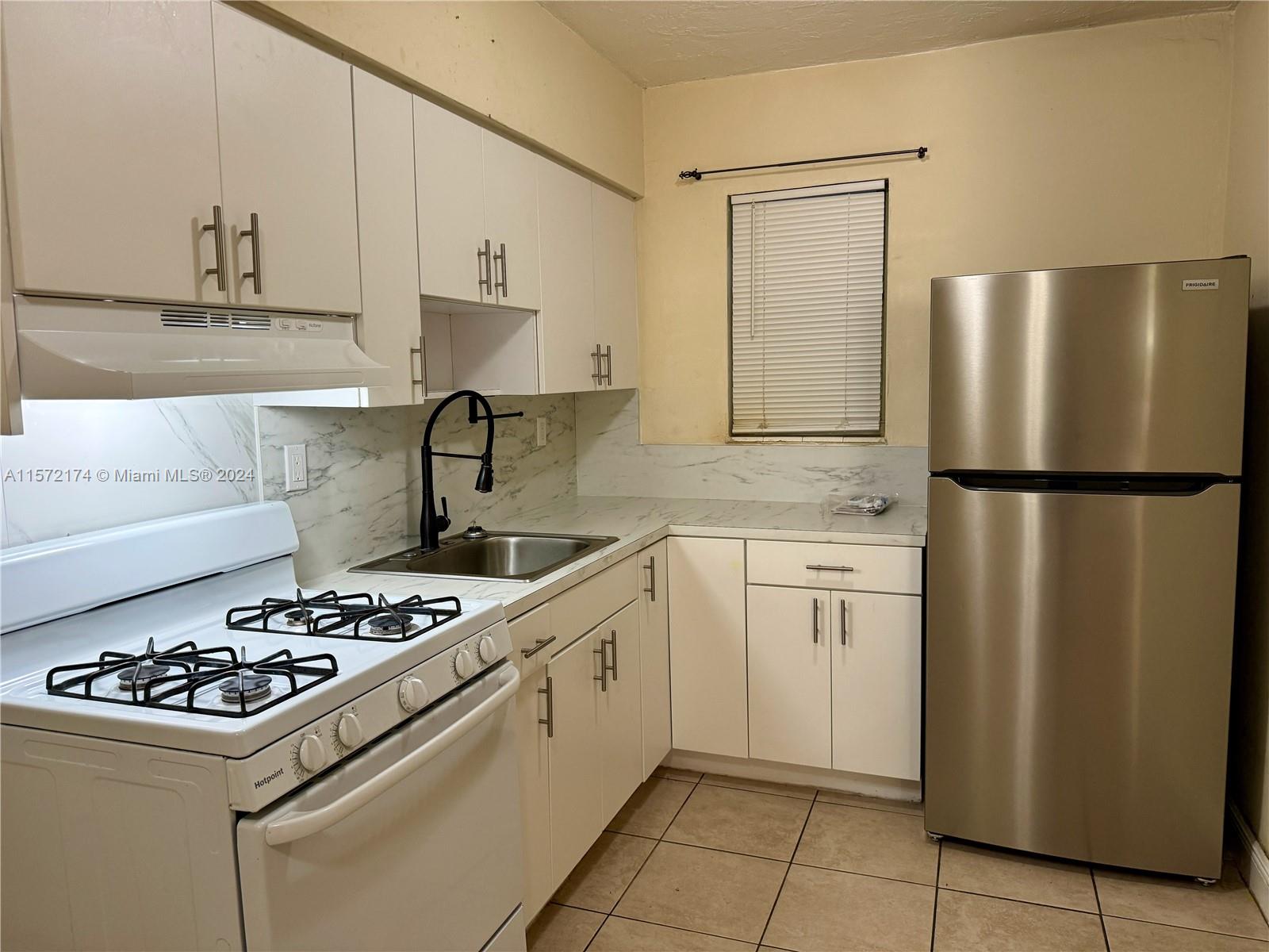 4250 Southwest 67th Avenue, Unit 6 Miami, FL 33155 - Photo 1 of 18 a kitchen with a stove a refrigerator and a sink