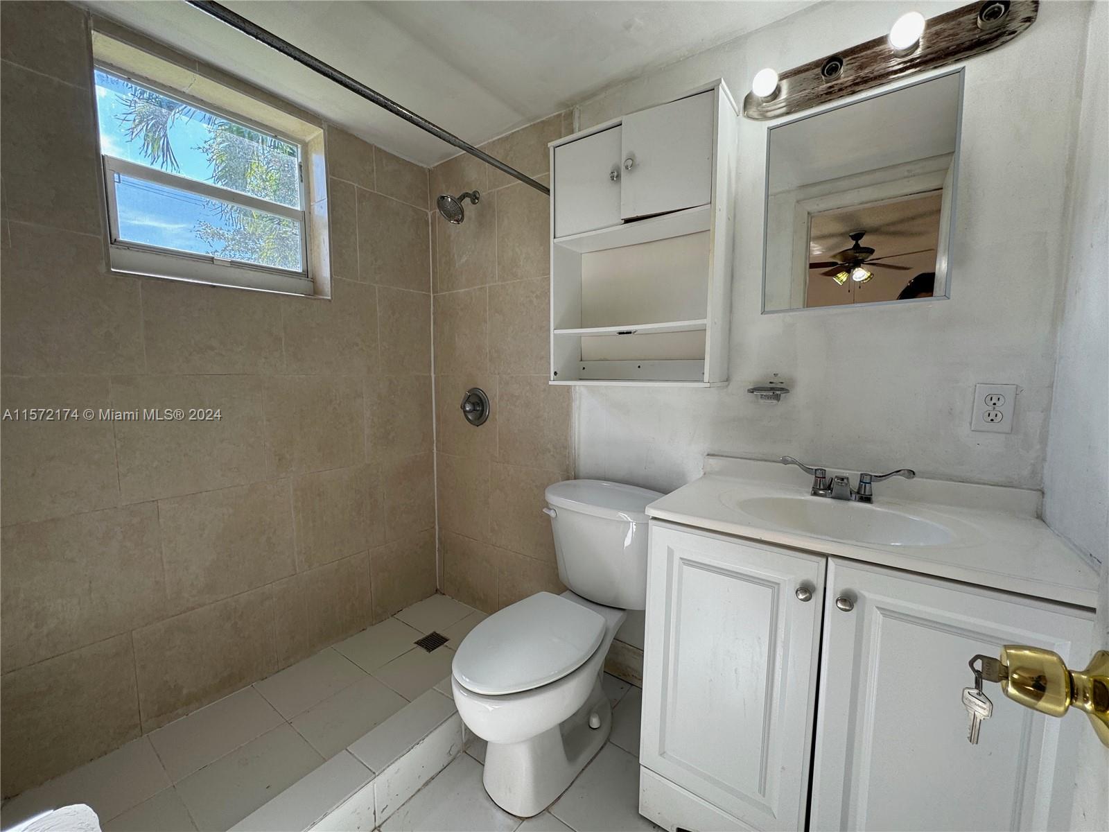 4250 Southwest 67th Avenue, Unit 6 Miami, FL 33155 - Photo 17 of 18 a bathroom with a granite countertop toilet a sink and mirror
