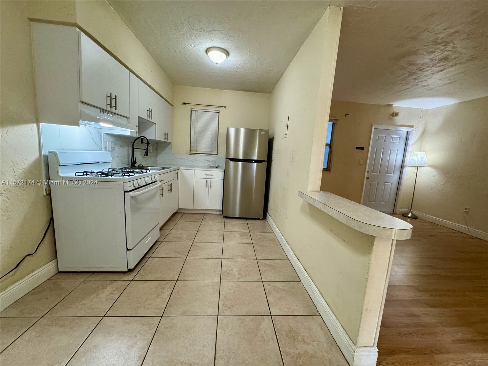 4250 Southwest 67th Avenue, Unit 6 Miami, FL 33155 - Photo 6 of 18 a kitchen with a sink a refrigerator and washer