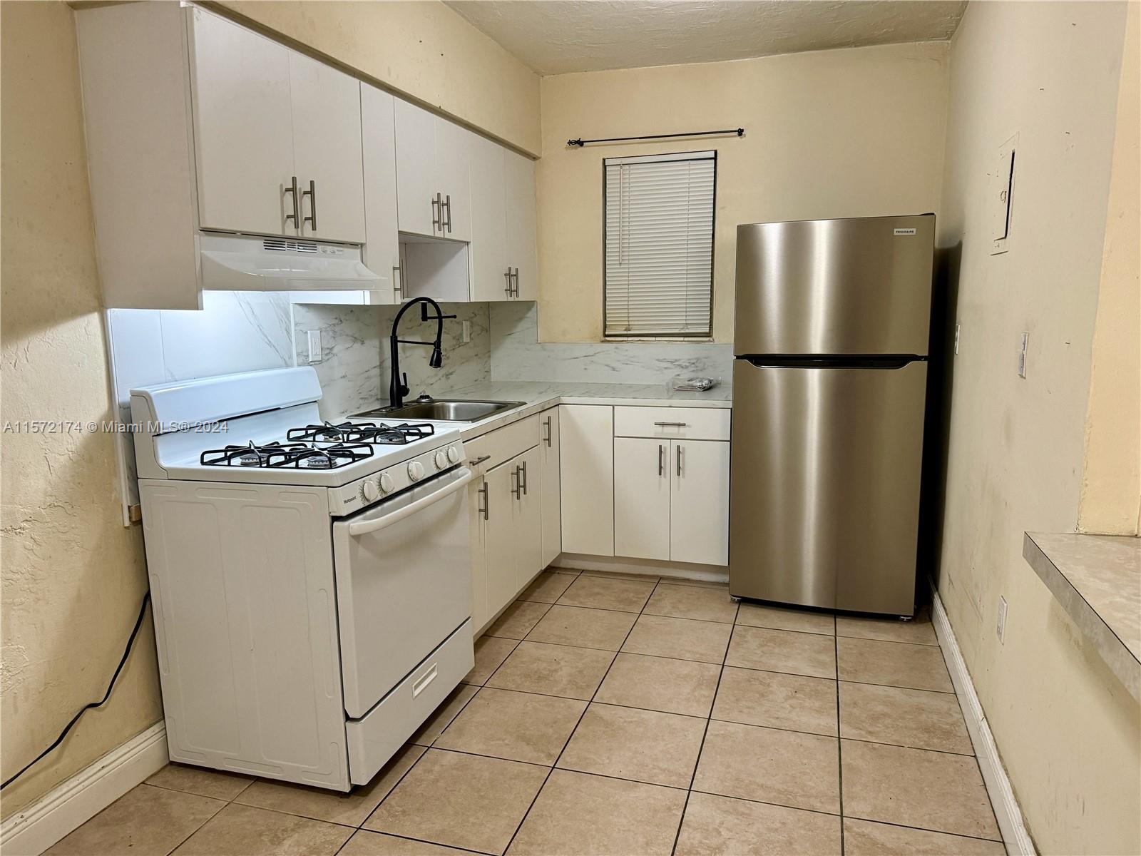 4250 Southwest 67th Avenue, Unit 6 Miami, FL 33155 - Photo 7 of 18 a kitchen with appliances a refrigerator and a stove top oven