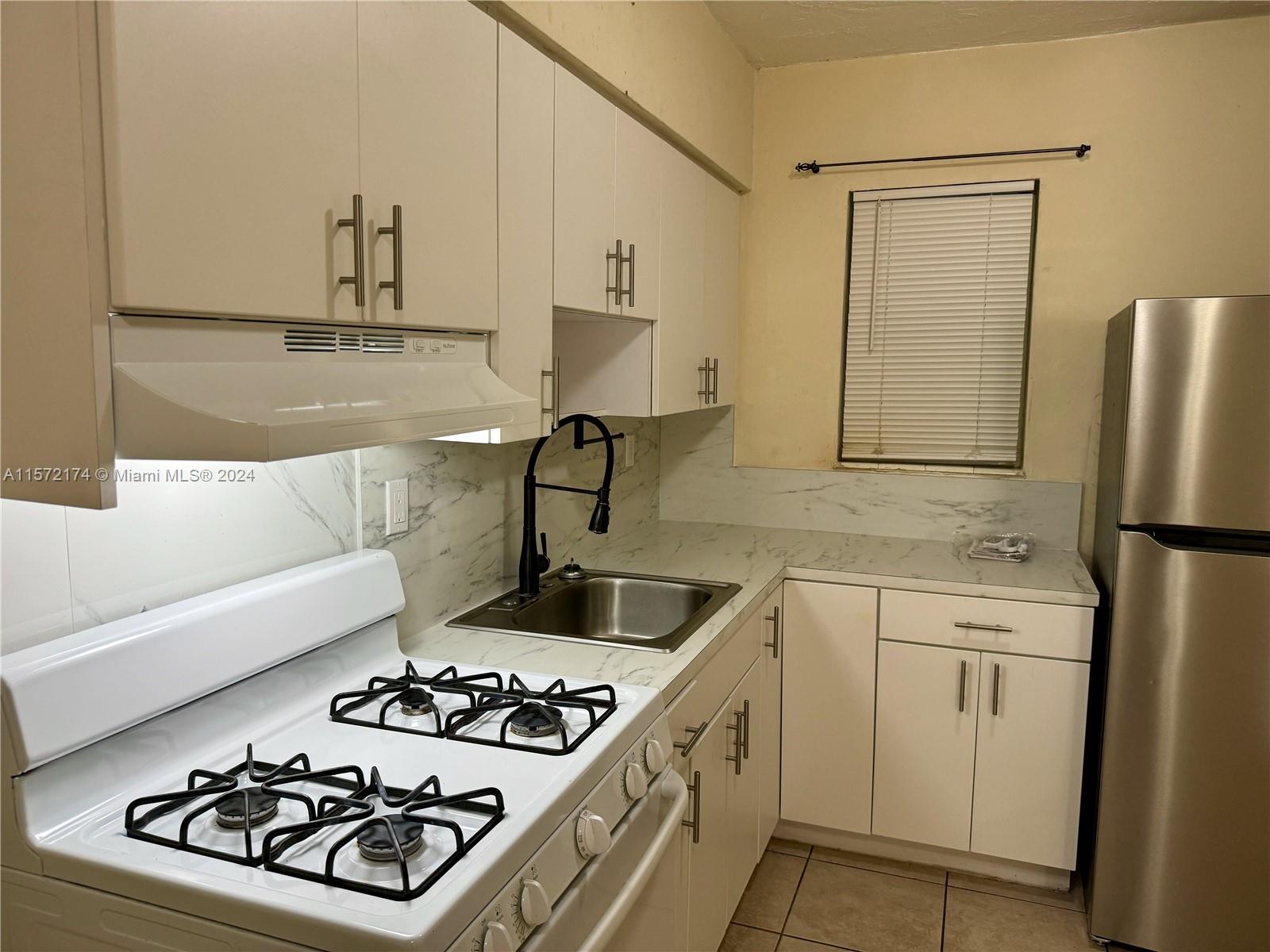 4250 Southwest 67th Avenue, Unit 6 Miami, FL 33155 - Photo 8 of 18 a kitchen with a stove and a sink