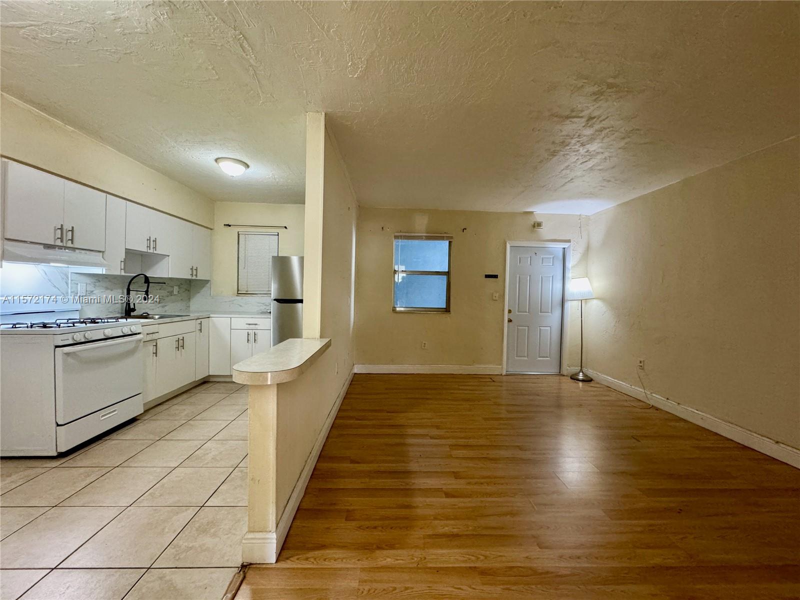 4250 Southwest 67th Avenue, Unit 6 Miami, FL 33155 - Photo 9 of 18 a large kitchen with cabinets and wooden floor