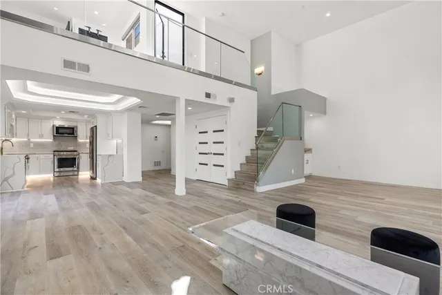 a view of a living room and kitchen with furniture wooden floor and a window